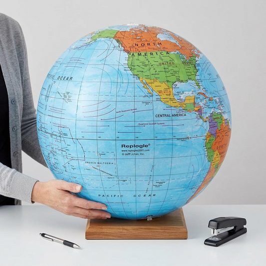 A person holding a large 27-inch inflatable Replogle political globe for scale comparison.