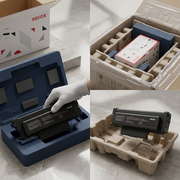 A close-up photograph of the Xerox black toner cartridge resting securely within shock-absorbing foam inserts for shipment.