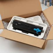 An open cardboard box revealing a Xerox toner cartridge nestled in fitted foam, with an instruction sheet visible.