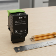 A scale reference photograph showing the Xerox C310 black toner cartridge next to a US quarter.