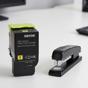 Scale reference photo for Xerox C310 yellow toner, shown next to a common office stapler.