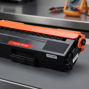 An extreme macro shot showing the fine texture of matte black and orange plastics on a high-yield toner cartridge.