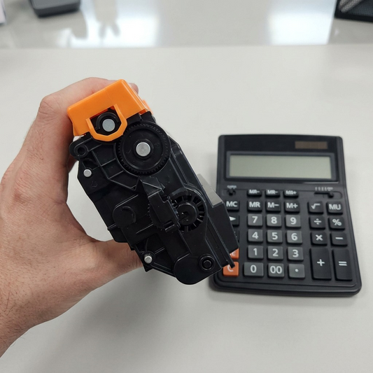 A hand holds the TN920XXL toner cartridge next to a calculator, emphasizing its full size.
