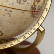 Macro close-up of Replogle Piedmont globe: textured map, gold-toned Meridian, French/Latin text.