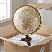 A premium close-up of a partially unboxed antique ocean globe, protected by custom foam inserts.
