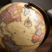 A detailed macro photograph showing the antique-style cartography, French language place names, and the red equatorial line of the Replogle Globemaster globe.