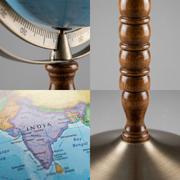 Macrophotography showing the wood-turned pedestal, metal base, full meridian, and cartography details of the globe.