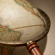 Extreme closeup of the texture, print, and materials on the antique style Commander II globe and stand.