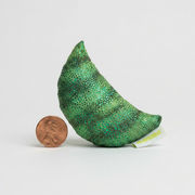Scale reference shot showing the green semi-precious stone sculpture next to a US nickel.