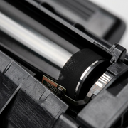 Extreme macro view of the HP CF258A toner cartridge's metallic drum surface.