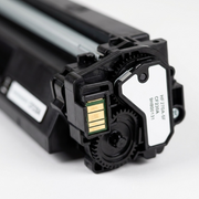 Extreme close-up of toner cartridge contacts and gear mechanism.