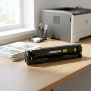 A realistic photo shows a yellow compatible HP CF402A toner cartridge set on a home office desk.