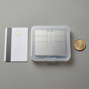 Olfa stainless steel scraper blades stacked in a clear case beside a credit card and a Canadian coin for scale.