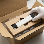 A photograph shows the Olfa carton cutter neatly unboxed, lying on top of its protective cardboard frame, removing anxiety about transit damage.