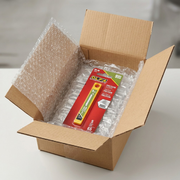 A close-up photograph of a small box filled with padding, holding the Olfa 5-Pack Snap Blades for protection, reduction in customer anxiety regarding potential shipping damage, on-brand ecommerce style.