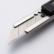 Macro photo detail of the Olfa 9mm SAC-1 graphic knife's stainless steel blade and snap-off lines.