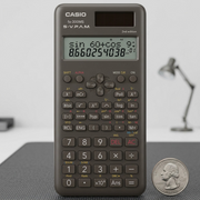 Casio FX300MSPLUS2 scientific calculator placed next to a quarter for size and scale reference.