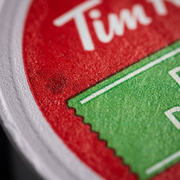 A detailed macro photograph showing the precise texture and print dots on the foil lid of the K-Cup pod.