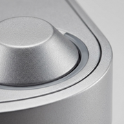 A macro photo focuses on the texture of the metallic finish and precision of the single button and indicator.