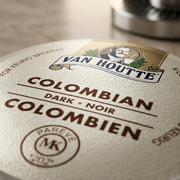 Macro photo detail of the embossed metal Van Houtte K-Cup lid with fine print texture.
