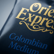 Macro photo detailing the rich texture, color, and gold lettering on the Orient Express coffee pod.