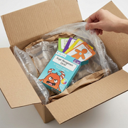Standard shipment box partially unsealed, revealing the fdmt Anger Management Cards! - English Version, nestled securely with air cushions and paper fill, demonstrating damage-free delivery.