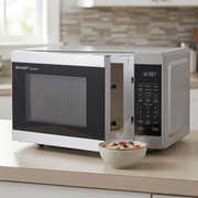 A SHARP SMC1162KSC microwave sitting on a beige laminate countertop next to a bowl of oatmeal.
