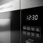 A close-up photograph of the SHARP SMC2264KSC microwave control panel showing the digital display and key buttons.