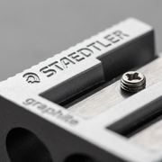 A macro inspection of a STAEDTLER metal sharpener, showing the debossed logo and a screw.