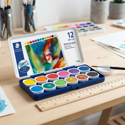 A photograph of the STAEDTLER watercolour paint set, open on a desk, next to a 30cm ruler.