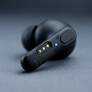 Extreme macro view of the Wicked Audio Mojo 700 earbud showing charging contacts and refined matte finish.