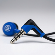 Macro close-up of blue Wicked Audio Brawl earbuds: precise 45-degree angle stereo jack, textured cable.