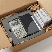 A Canon LS-63TG calculator securely packed in a shipping box with foam and protective paper.