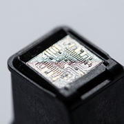 Macro photograph capturing the precise electrical contact pads on the base of a Canon PG-210 ink cartridge.