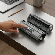 Canon ink tank with a realistic pencil on a wooden surface for size comparison.