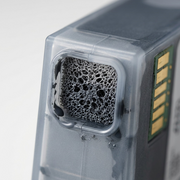 Macro shot focusing on the mesh filter and deep grey ink of a Canon CLI-221 Grey Ink tank.