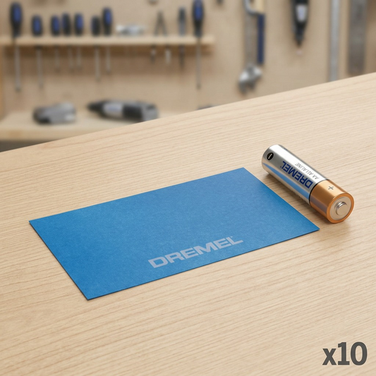 A scale reference image showing the single Dremel BT41-01 Blue Tape sheet placed flat on a wooden desk next to a standard AA battery.