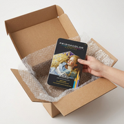 An open, reusable shipping box with bubble wrap padding, revealing the Prismacolor Verithin 36-pencil box set (MPN: 2428) undamaged, emphasizing secure packaging for protected delivery.