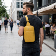 Lifestyle photo of the Bugatti Rick Ross Sling Bag worn by a person in a city, natural light.