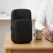 Comparison shot showing the true size of the Bugatti Rick Ross sling bag next to common objects.