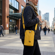 PDP Lifestyle shot of the Bugatti B2 Voltage Yellow crossbody bag in an urban travel setting.