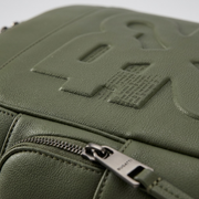 Detailed close-up of a green leather-like backpack texture with a large debossed 'R2' logo.