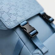 An extreme close-up photograph showcasing the intricate, embossed textured pattern and detailed buckle hardware on the premium PU blue fabric of the Bugatti Rick Ross Backpack.