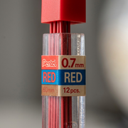 Extreme macro-view detailing printed text 'RED 0.7mm' on label and clear tube texture with red lead visible.