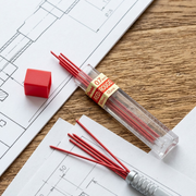 Pentel 0.7mm red leads in and out of the tube on a technical drawing surface.