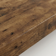 Extreme close-up of a rustic wood beam, highlighting deep grain, knots, and dark patina.