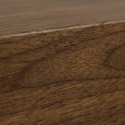 Extreme close-up of dark walnut-stained wood grain texture on a floating shelf.