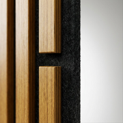 Macro closeup of the acoustic panel, showing the precision edges of the wood slats, the rich wood grain, and the texture of the black felt backing, highlighting the material quality and craftsmanship.