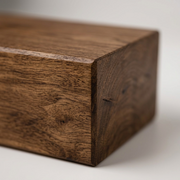 A macro photograph of the wood mantel's walnut finish, highlighting grain detail and precision craftsmanship.