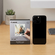 Scale reference photo for Canon SELPHY XS-20L Ink Set, shown next to a standard smartphone.